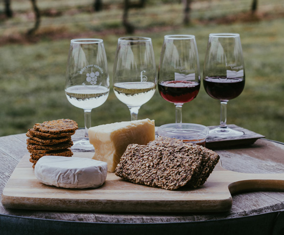 wines and bread on brown wooden chopping board - Photo by Chelsea Pridham on Unsplash