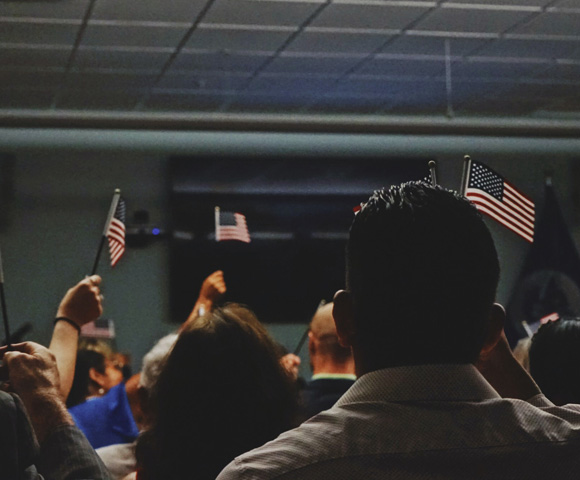 immigrants holding flag of U.S.A miniature - Photo by Kerwin Elias on Unsplash